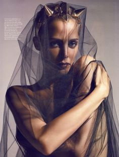 a woman wearing a veil and posing for a photo shoot with her hands on her hips