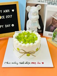 there is a cake with grapes in it on the table next to pictures and photos