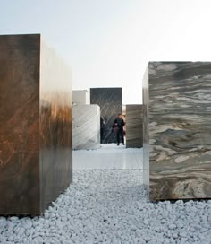 a couple of people that are standing in front of some rocks and wood blocks on the ground