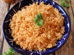 a blue and white bowl filled with rice on top of a wooden table