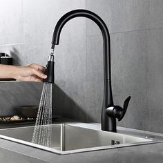 a person is washing their hands under the faucet in a kitchen sink,