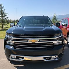 two pickup trucks parked next to each other in a parking lot