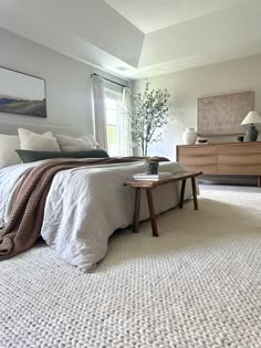 a bedroom with a large bed, dresser and window in it's center area