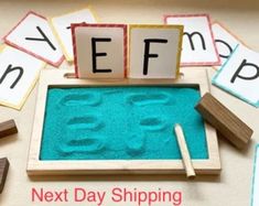 a wooden tray with letters and numbers on it next to blocks that spell out the word eff