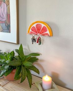 a potted plant sitting on top of a wooden table next to a candle holder