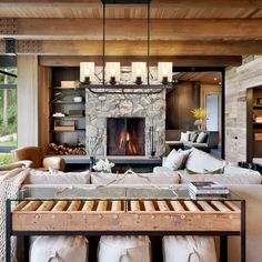 a living room filled with furniture and a fire place in the middle of it's wall