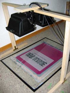 an electronic device sitting on top of a glass floor next to a box with some wires in it