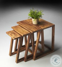 three wooden stools with a plant in the middle one on each side and another on the other