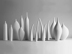 a group of white vases sitting on top of a table