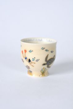 a white cup with birds and flowers on it