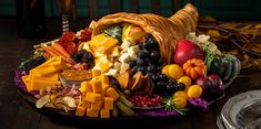 a platter filled with fruit, cheese and crackers