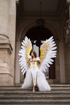 a woman dressed as an angel standing on some steps