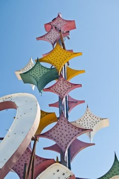 a large metal sculpture with many different colored stars on it's top and bottom