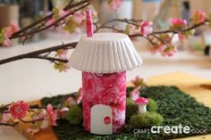 a pink and white lamp sitting on top of a wooden table next to a tree