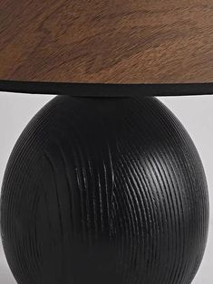 a black vase with a wooden top on a white background