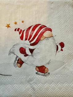 a white napkin with a red and white striped hat on it's head, riding a skateboard