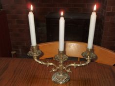 three candles are lit on a wooden table