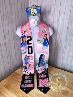 a pink and black neck tie with pictures of women in the front, on top of a white mannequin