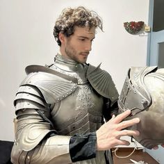 a man dressed as a knight holding something in his hand