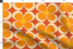 an orange and white flower print fabric with yellow circles on the bottom, in front of a ruler