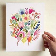 a person holding up a card with flowers on it