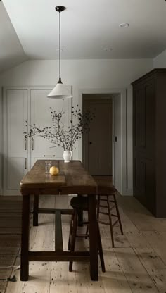 an image of a dining room setting with wooden table and stools in it,