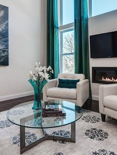 a living room filled with furniture and a flat screen tv mounted on the wall above a fireplace