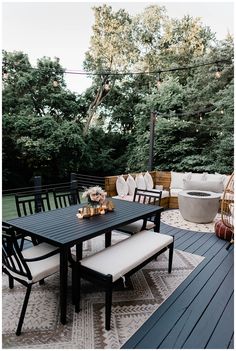 an outdoor dining table and bench on a deck