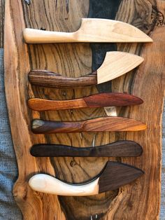 several different types of knives are on display in a wooden holder that is made out of wood