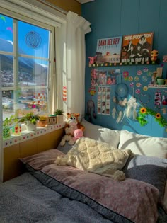 a bedroom with blue walls and pictures on the wall above the bed, along with stuffed animals