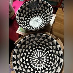 two black and white bowls sitting on top of each other