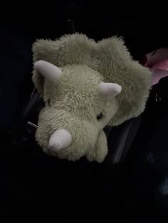 a stuffed animal in the back seat of a car with its head sticking out from it's side