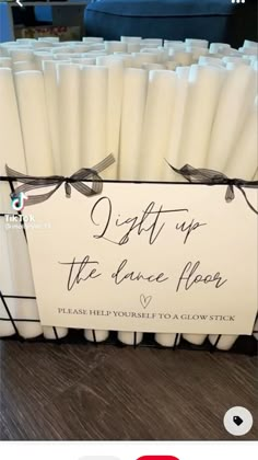 some white candles are in a box on the table and there is a sign that says don't up to dance paper