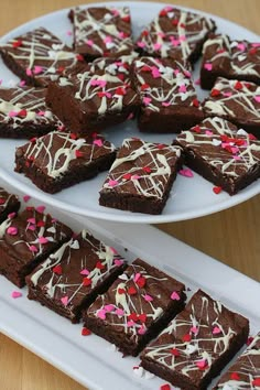 chocolate brownies with white frosting and sprinkles on a platter