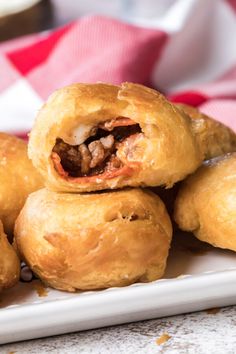 several pastries stacked on top of each other on a white plate with a red and white checkered napkin