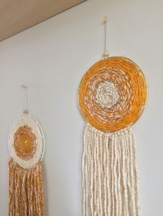 two wall hangings made out of yarn and rope on the wall next to each other