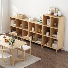 a dining room table and chairs in front of a bookshelf