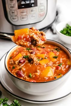 a spoon full of chili and potatoes with an instant pot in the background