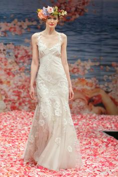 a woman in a wedding dress with flowers on her head