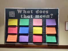 a bulletin board with sticky notes attached to it that says what does that mean?