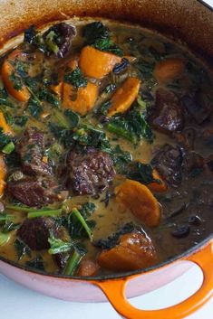 a pot filled with stew and vegetables on top of a stove