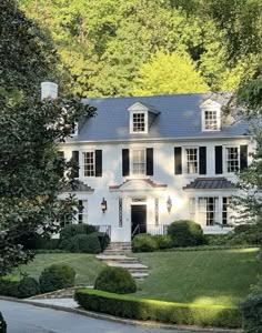 a large white house surrounded by trees and bushes