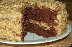 a chocolate cake with frosting and nuts on top is cut in half to show the inside