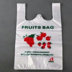 a white shopping bag with fruit printed on the front and side, sitting on a gray surface