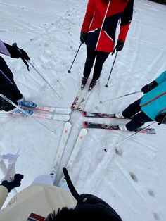 four people standing in the snow with skis on their feet and poles attached to them