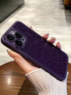 a woman's hand holding up a purple case with glitter on the front and sides