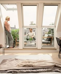 a man and woman are looking out the window at each other in their living room