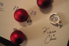 three red christmas balls on top of a white paper