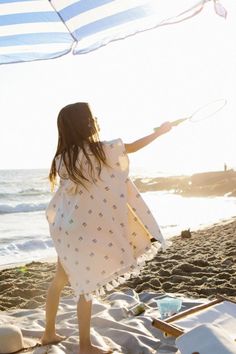 girl stands on the beach in front of the ocean at sunset, holding a butterfly catcher, wearing a cream colored hooded poncho towel with black lines stacked detailing and white tassels Towel Poncho, Towels Kids, Fun In The Sun, Terry Cloth, Ponchos, Hand Warmers, Pocket Pouch, Sea Shells, Get Ready