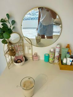 a bathroom vanity with a mirror, soap dispenser and various personal care items